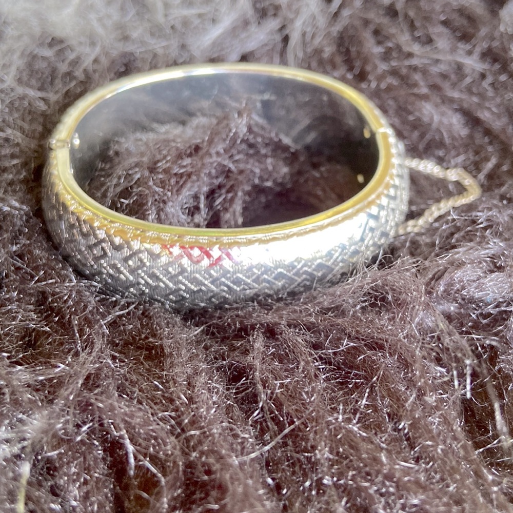 Silver tone womens vintage etched bangle bracelet with safety chain.